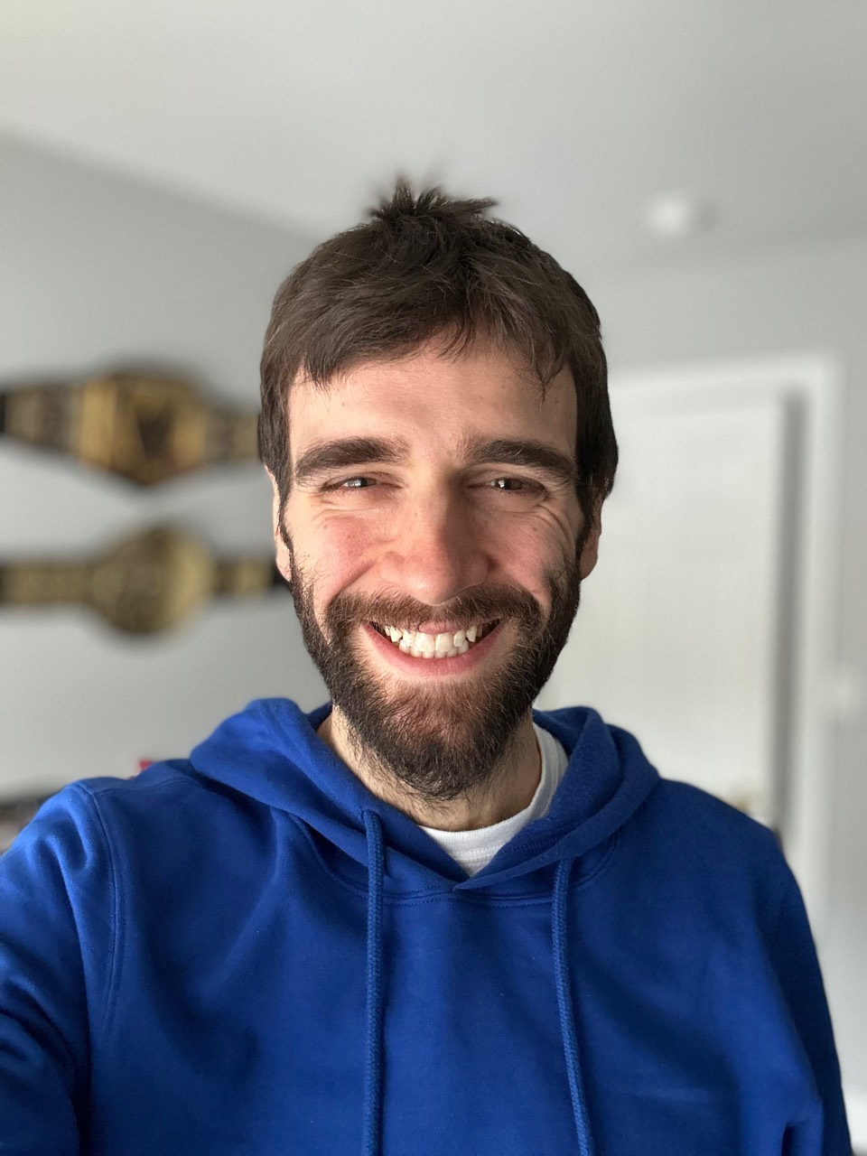 Julien Capron smiling in a blue hoodie